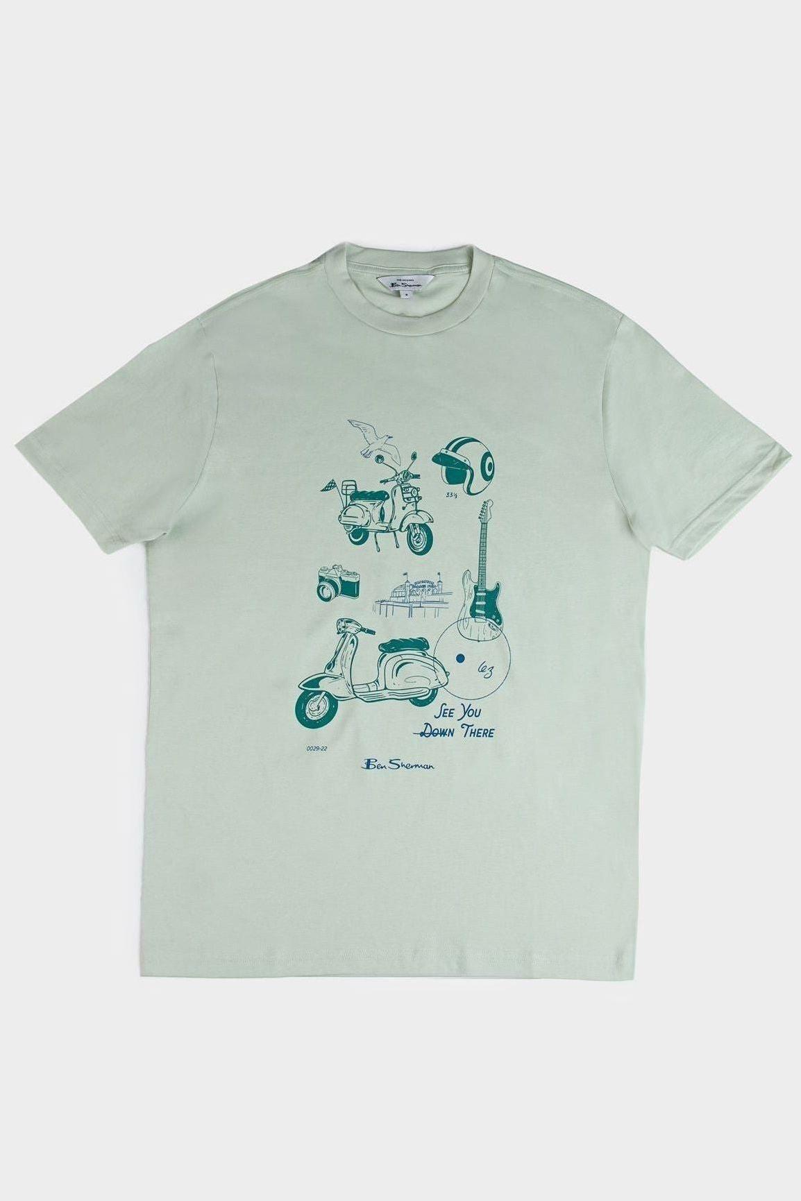 Flat lay of a pistachio green Ben Sherman t-shirt featuring a retro sketched Mod Zone print with a scooter, helmet, guitar, camera, and seagull illustrations.