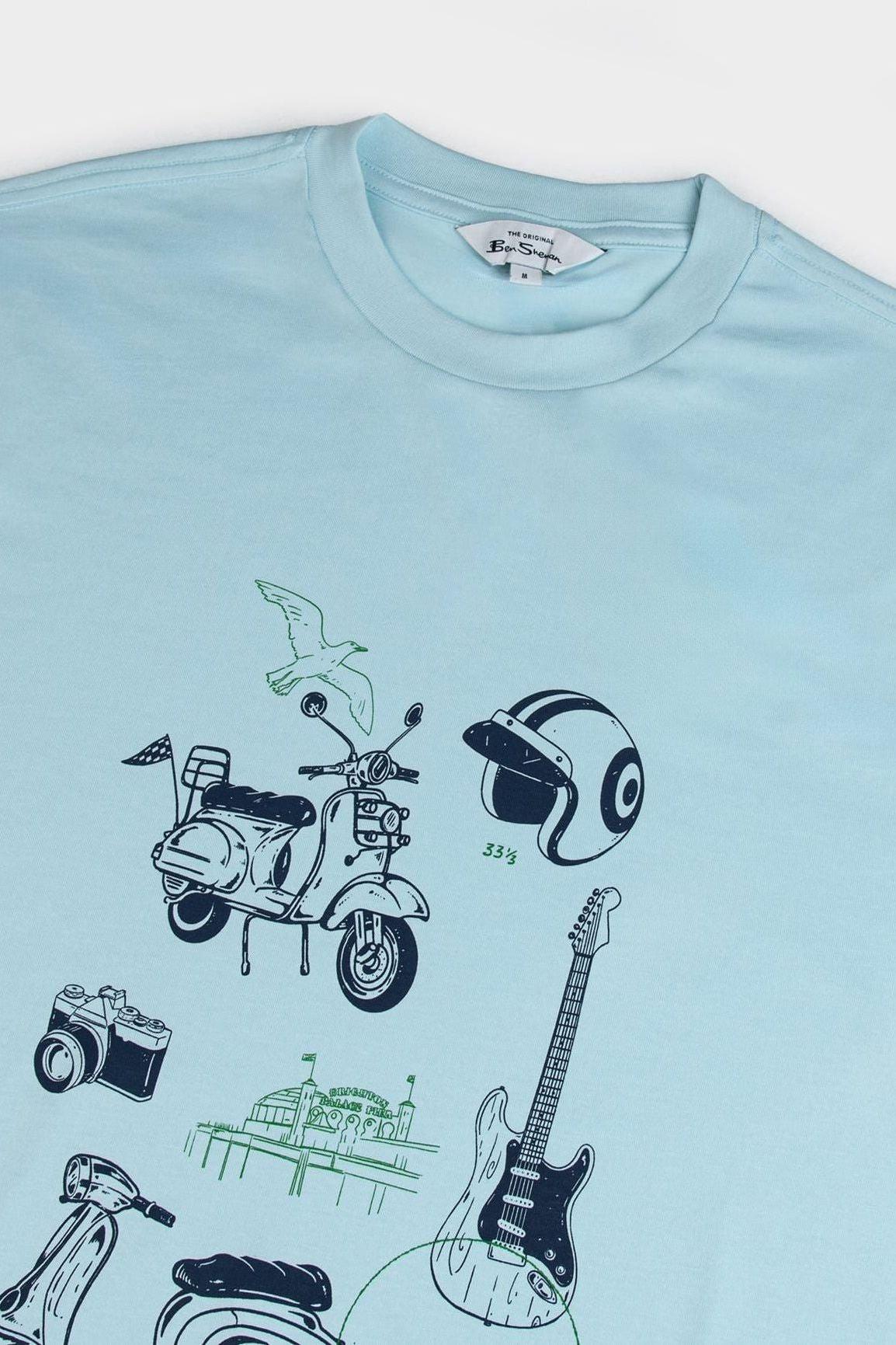 Close-up view of Ben Sherman Sketched Mod Zone Tee in Summit showcasing vintage-style scooter, guitar, camera, and helmet graphic print on soft light blue fabric.