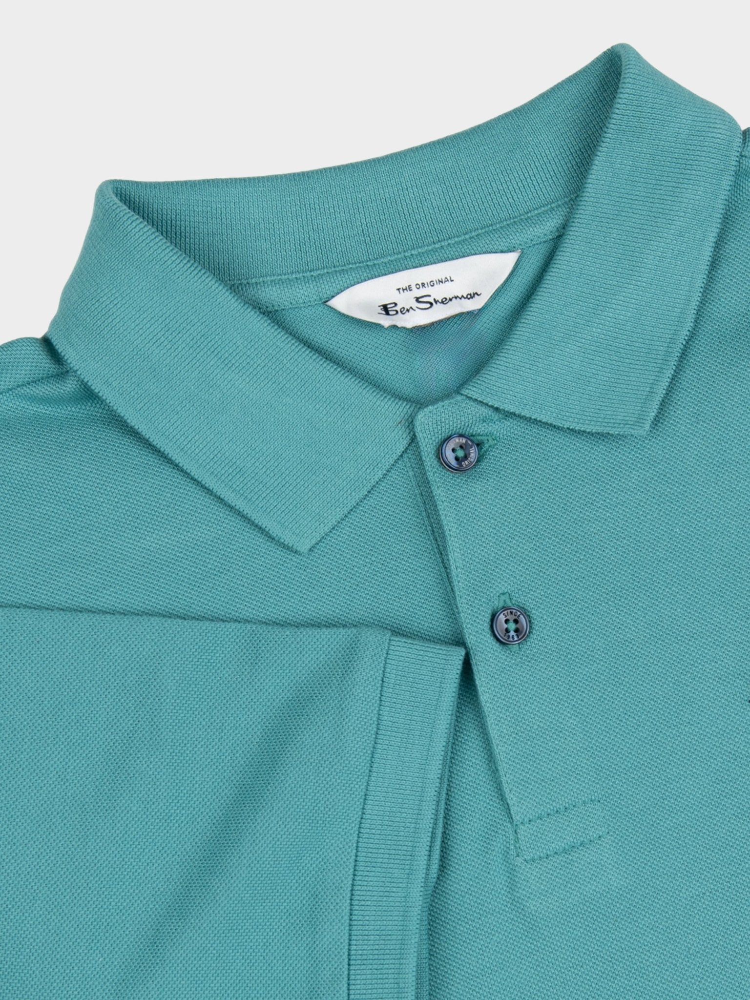 Ben Sherman cotton pique polo in Aqua Teal, close-up detail of the flat knit collar, two-button placket and branded neck label