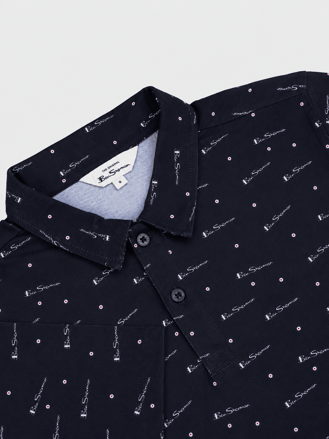 Ben Sherman Target All Over Print Polo in Black – close-up detail of collar and button placket with all-over logo print