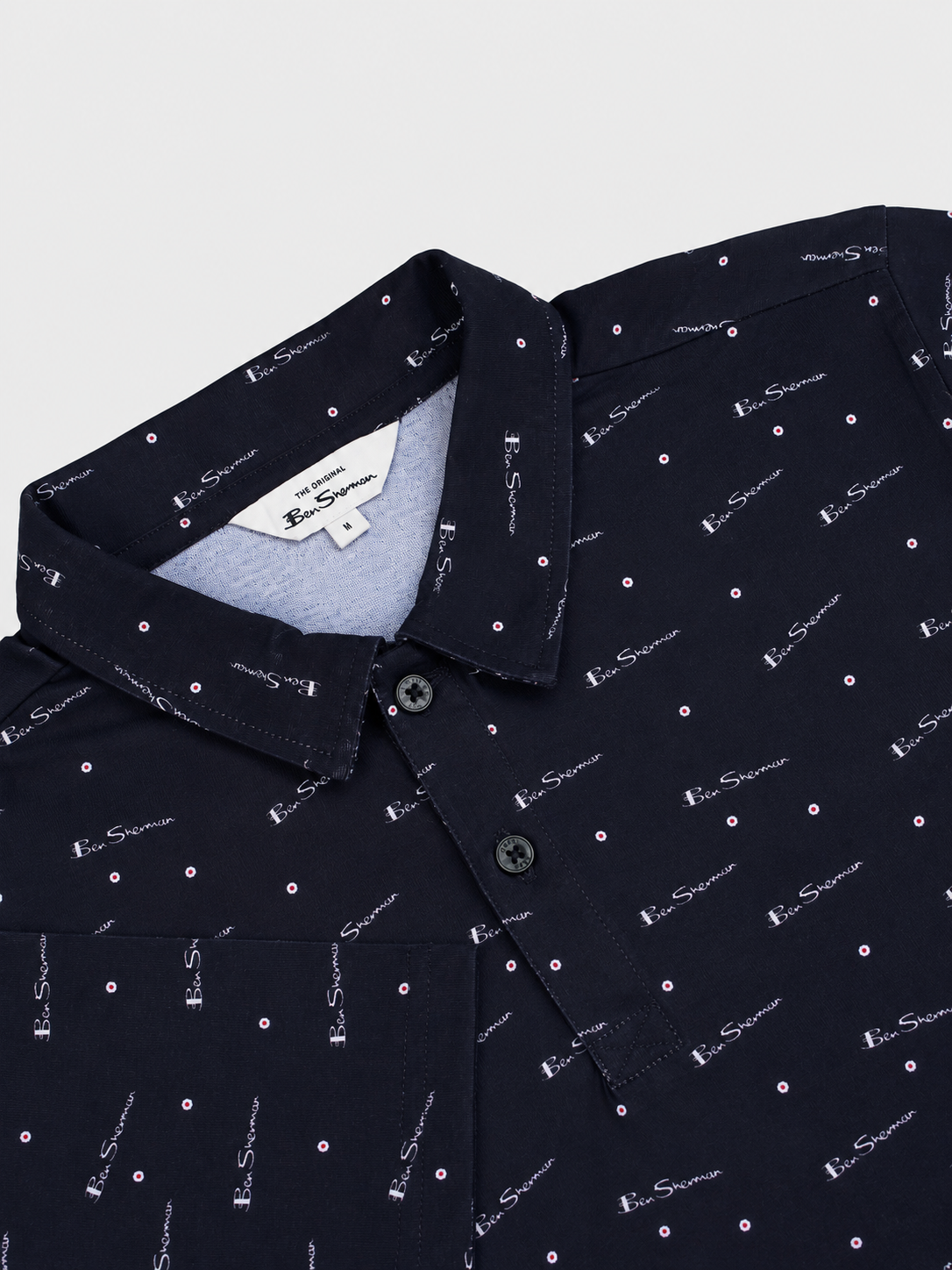 Ben Sherman Target All Over Print Polo in Black – close-up detail of collar and button placket with all-over logo print