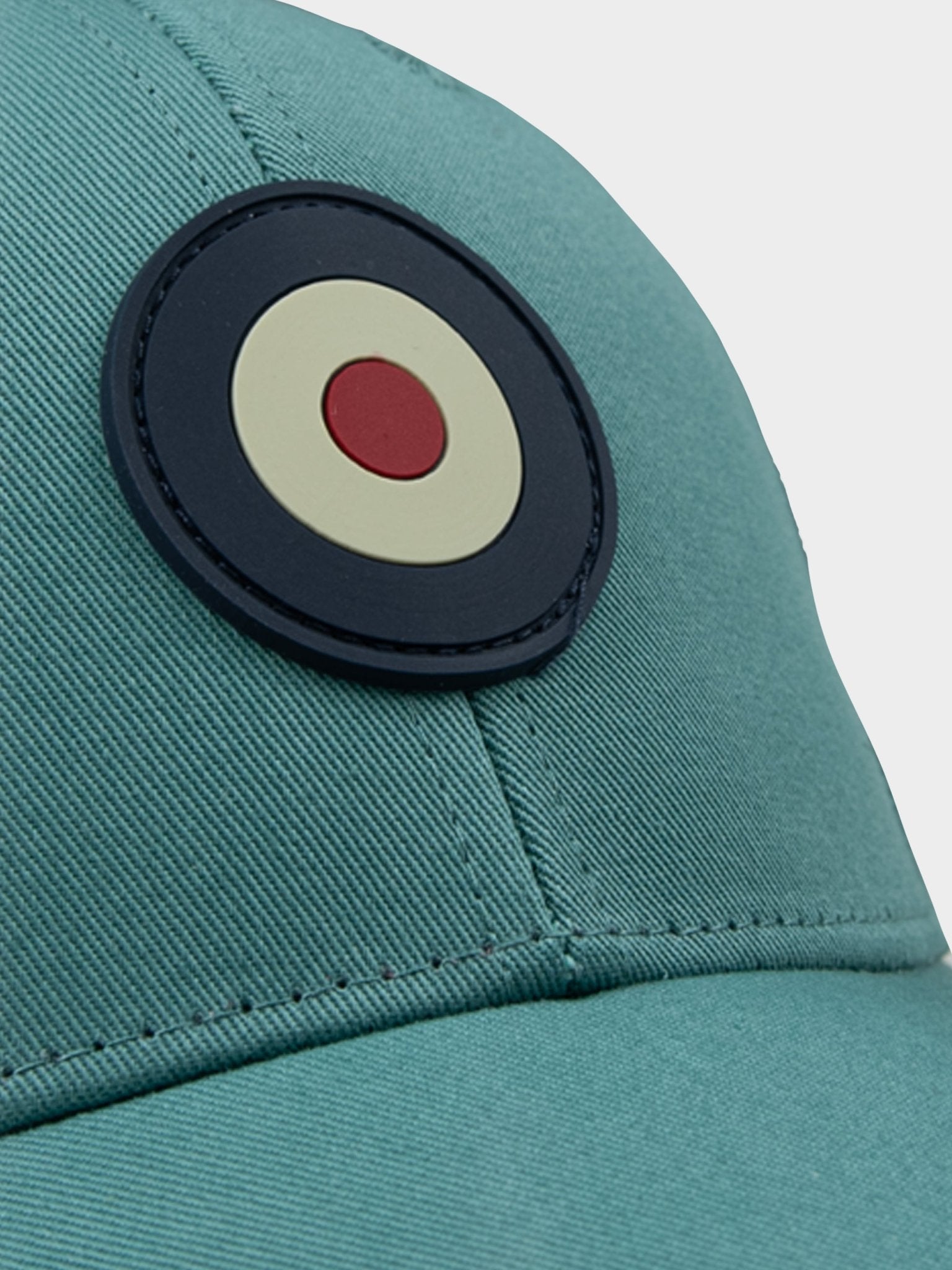 Close-up of rubberized Ben Sherman Target emblem on Adult Targy Peak Cap in Aqua Teal