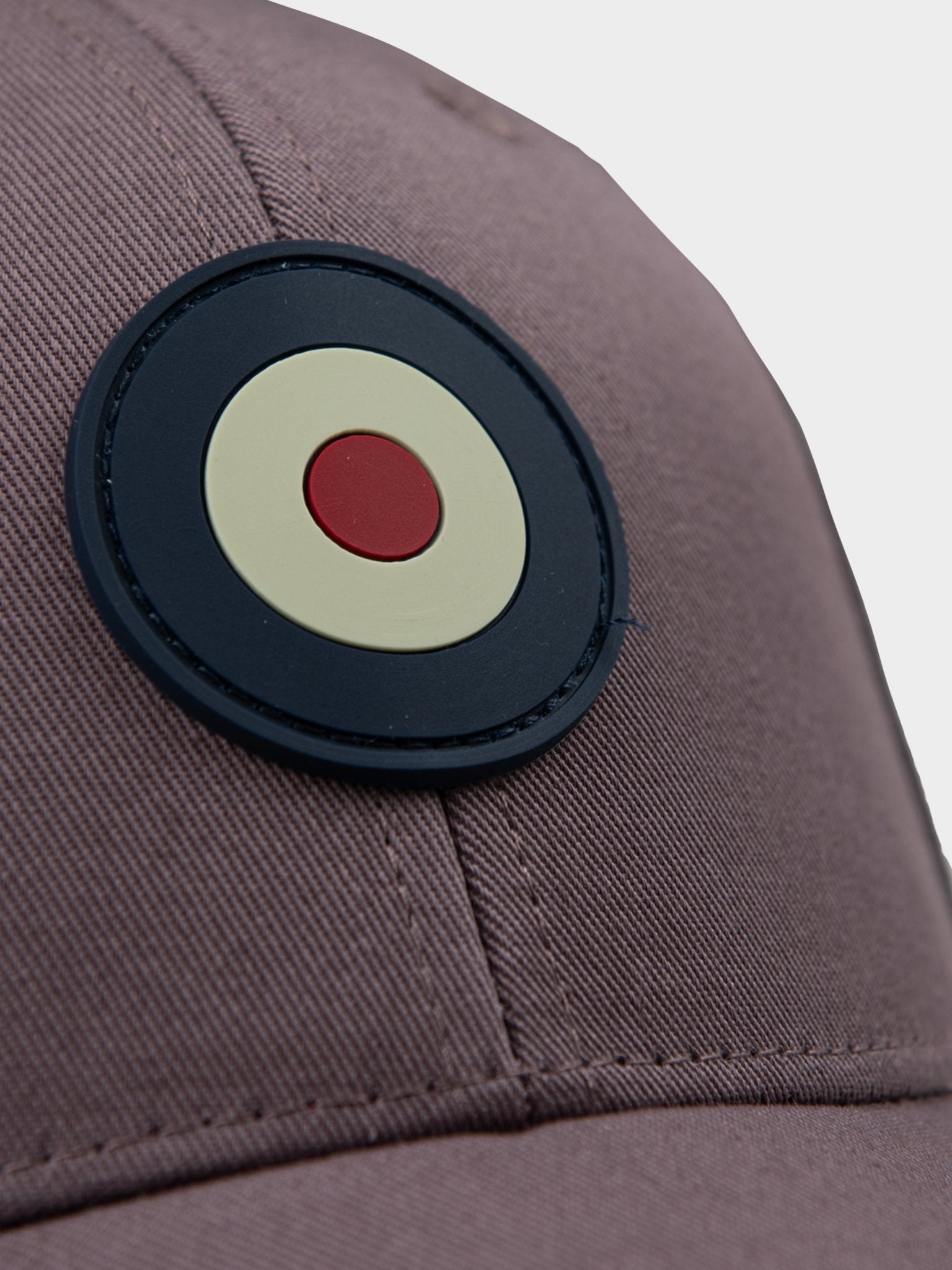 Close-up of rubberized Ben Sherman Target emblem on Adult Targy Peak Cap in Cocoa Powder