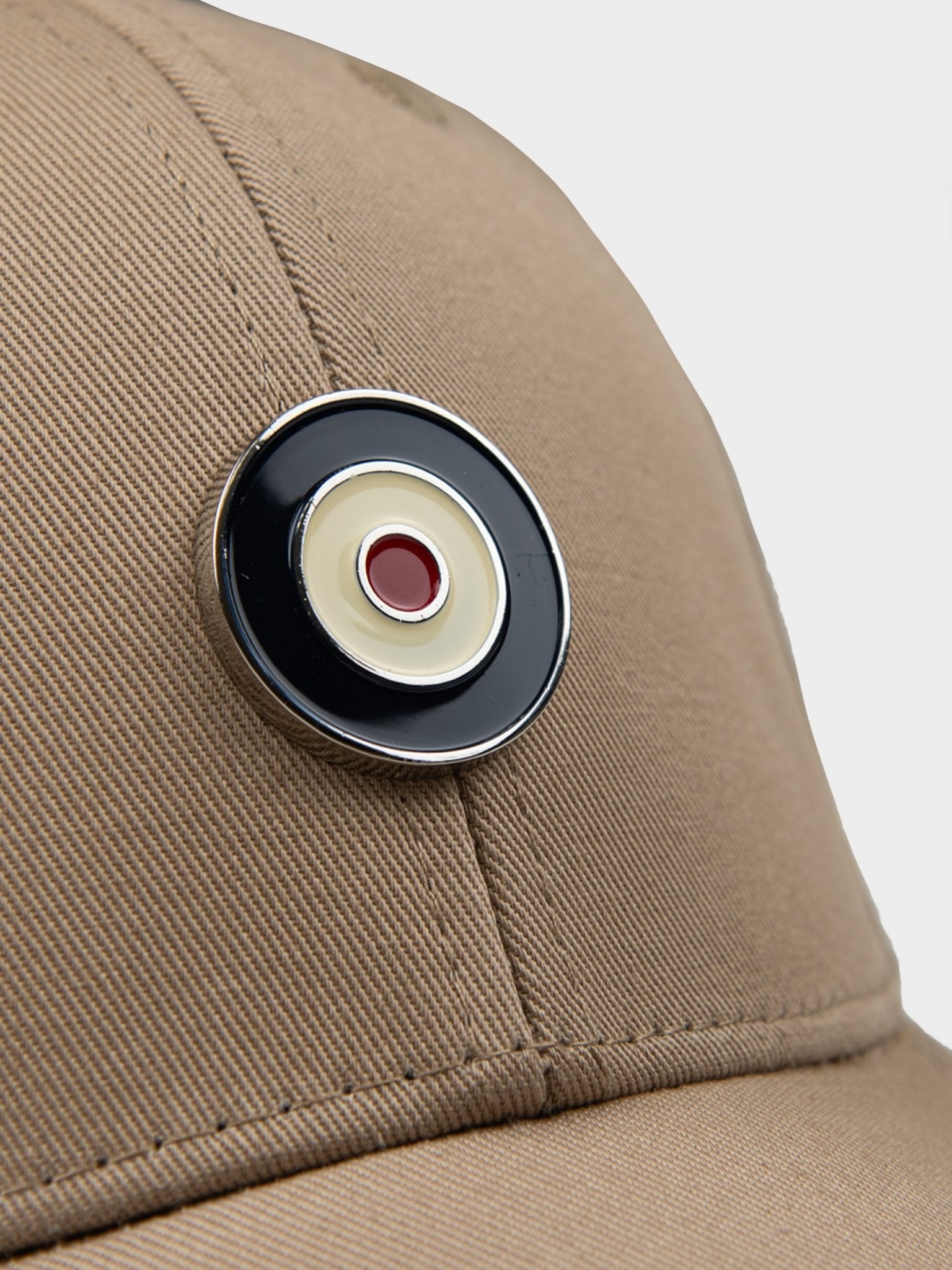 Close-up detail of Ben Sherman Metal Target Badge Cap in Cornstalk showing metal target badge emblem