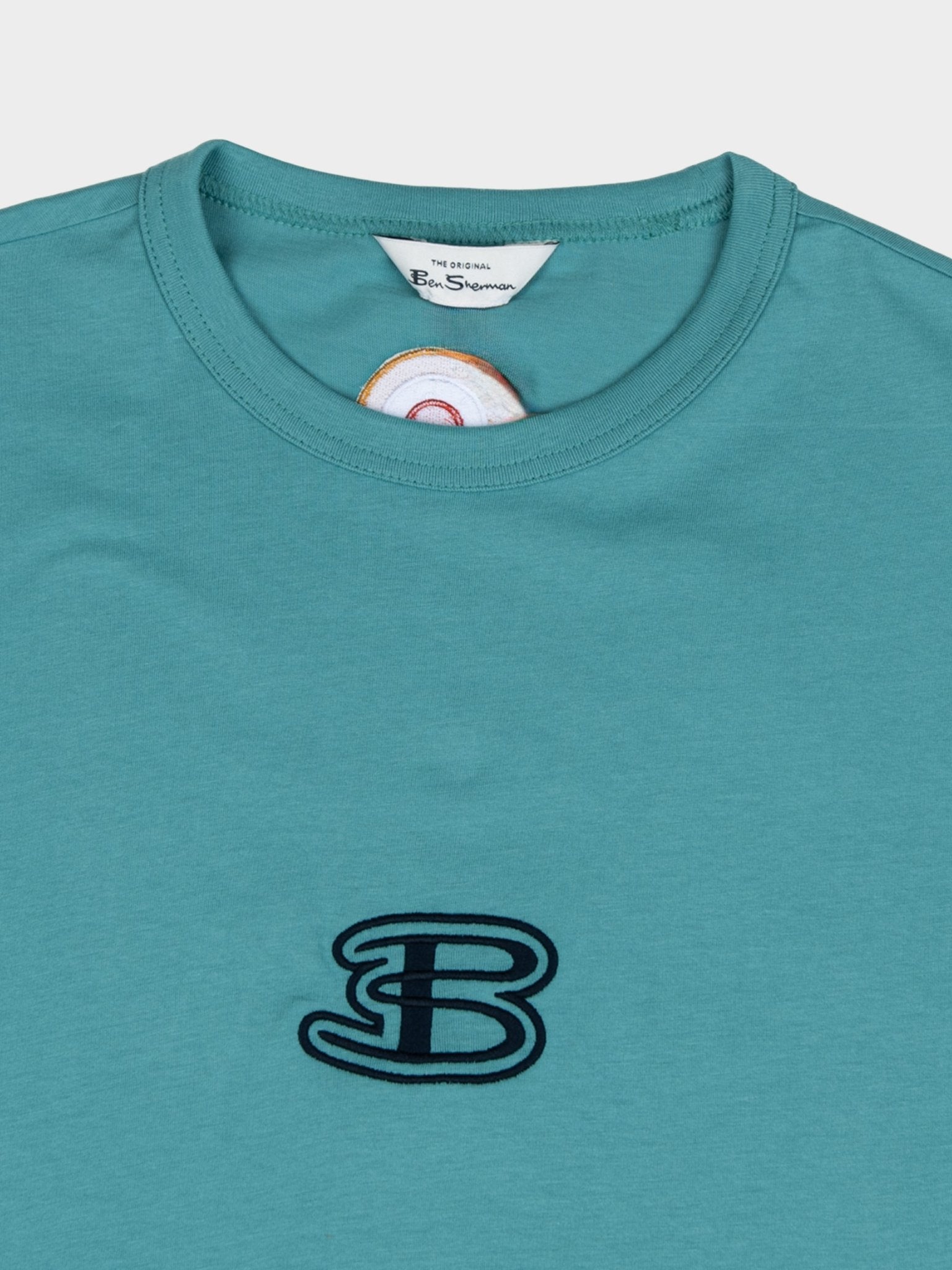 Close-up of Ben Sherman Athleisure Tee in Aqua Teal – embroidered B logo detail and contrast stripe sleeve on cotton men's t-shirt