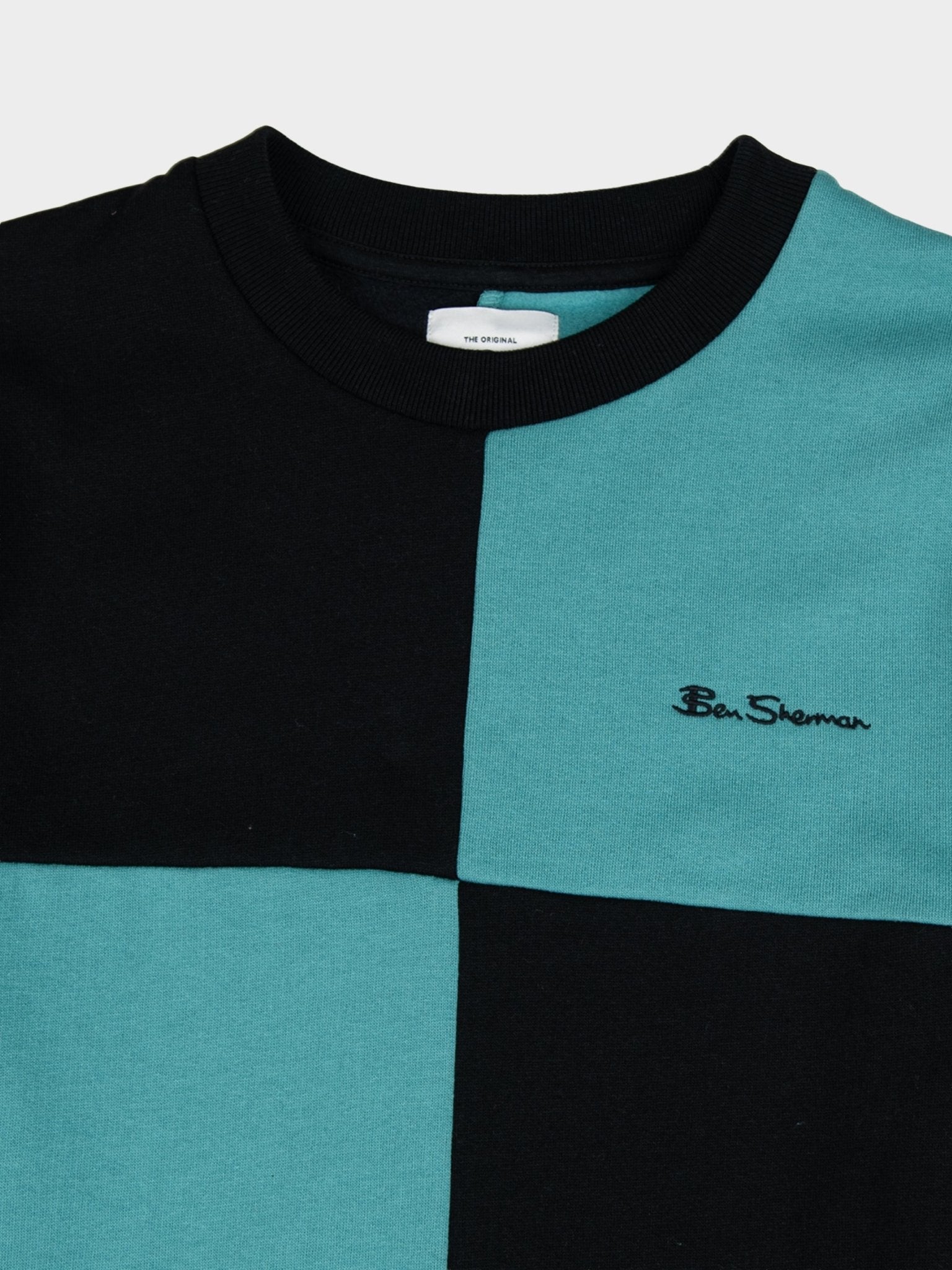 Close-up detail of Ben Sherman men's colour block crew neck sweater in Aqua Teal – ribbed crew neckline, colour-blocked panels and embroidered Ben Sherman logo on premium cotton knit