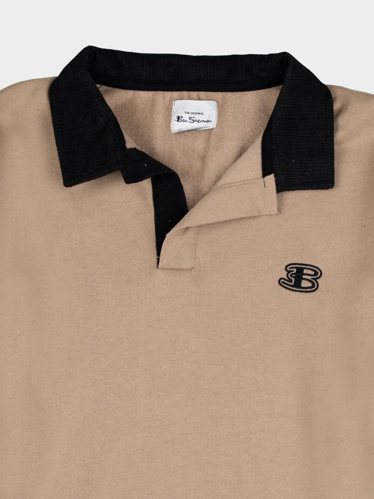 Close-up detail of Ben Sherman men's polo sweater in Cornstalk – black contrast polo collar, embroidered B logo on chest and Ben Sherman woven label on premium cotton knit